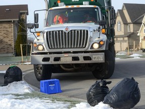 Crews collect garbage in northeast London, where new rules limiting households to three bags of trash at curbside kicked in Monday. (MORRIS LAMONT, The London Free Press)