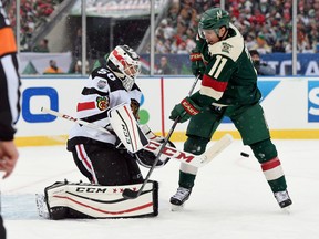 Corey Crawford of the Chicago Blackhawks makes a stop as Zach Parise of the Minnesota Wild looks for the rebound at the TCF Bank Stadium during the Stadium Series game on Feb. 21, 2016. (Hannah Foslien/Getty Images)