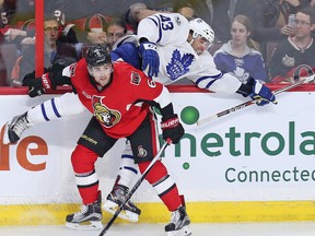 Sens defenceman Chris Wideman checks Leafs centre Nazem Kadri into the boards during Saturday night’s game. (WAYNE CUDDINGTON/Postmedia Network)