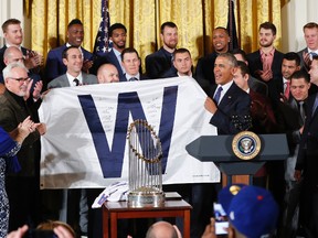 President Barack Obama holds up a 'W' flag signed by the Cubs during a ceremony in the East Room of the White House in Washington, Monday, Jan. 16, 2017, where the president honoured the 2016 World Series Champion baseball team. On the far left are Cubs co-owner Laura Ricketts, and manager Joe Maddon. (AP Photo/Pablo Martinez Monsivais)