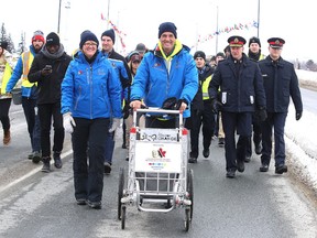 Joe Roberts makes his way over the Bridge of Nations with community leaders and supporters in Sudbury, Ont. on Sunday January 15, 2017. Joe Roberts is pushing a shopping cart across Canada to raise awareness and funds for youth homelessness. Gino Donato/Sudbury Star/Postmedia Network
