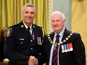 St. Thomas Police Chief Darryl Pinnell, left, accepts a member designation to the Order of Merit of the Police Forces from Governor General David Johnston last September at Rideau Hall in Ottawa.