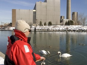 A man is pictured fishing next to the Lakeview coal generating plant in Mississauga in 2005. The plant was eventually torn down. (Toronto Sun files)