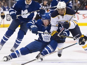Toronto Maple Leafs defenceman Morgan Rielly battles for the puck against Buffalo Sabres left wing Evander Kane during first period NHL hockey action in Toronto on Tuesday, January 17, 2017. (THE CANADIAN PRESS/Nathan Denette)