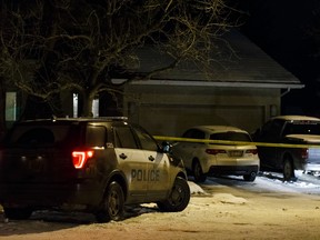 An Edmonton Police Service vehicle and police tape surround a home at 213 Heagle Cresent on Tuesday. Police are investigating two suspicious deaths. (IAN KUCERAK)