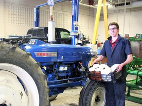 St. Anne's student Evan Krebs in front of his tractor that he reconfigured to run on biofuels soybean and canola oil. (Justine Alkema/Clinton News Record)