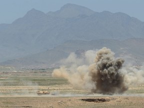 Afghan National Army (ANA) soldiers take cover during a controlled explosion of Improvised Explosive Devices (IED) during a military exercise on the outskirts of Kabul on April 30, 2014. AFP PHOTO/SHAH MaraiSHAH MARAI/AFP/Getty Images