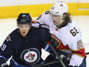Jets defenceman Toby Enstrom (left) and Panthers right winger Jaromir Jagr (right) tangle during NHL action in Winnipeg on Dec. 15, 2016. (Brian Donogh/Winnipeg Sun)