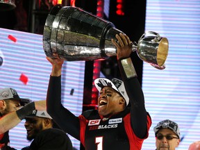 Redblacks quarterback Henry Burris hoists the Grey Cup at BMO Field in Toronto after defeating the Stampeders on Nov. 27, 2016. Burris is leaning towards retiring from football. (Michael Peake/Postmedia Network/Files)