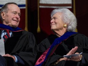 Former president George H.W. Bush and Barbara Bush listen as their son, then-U.S. president George W. Bush, delivers the commencement address during the Texas A&M University graduation ceremony at Reed Arena in College Station, Texas, on Dec. 12, 2008. (SAUL LOEB/AFP/Getty Images)