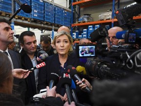 France's Front National (FN) far-right party's President and presidential candidate for the 2017 election Marine Le Pen (C), flanked by FN vice-president Florian Philippot (2-L), speak to journalists at the Fermap manufacturing factory in Forbach, eastern France, on January 18, 2017. / AFP PHOTO / PATRICK HERTZOGPATRICK HERTZOG/AFP/Getty Images