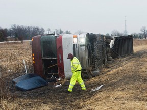 A tow truck operator walks around a bus that was carrying the Columbus Cottonmouths of the SPHL that was involved in a rollover crash on Interstate 74 near Morton, Ill., on Thursday, Jan. 19, 2017 (David Zalaznik/Journal Star via AP)