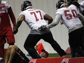 Atlanta Falcons defensive tackle Ra'Shede Hageman and a defensive end Brooks Reed jump over an unidentified man as they work during an NFL football practice , Thursday, Jan. 19, 2017, in Flowery Branch, Ga..  (AP Photo/John Bazemore)
