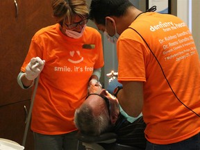 BRUCE BELL/THE INTELLIGENCER
Dr. Kuldeep Sandhu (right) and dental assiatnt Linda Guthrie perepare a patient for an extraction during Dentistry From The Heart at Picton Dental Centre on Friday. The annual event draws approximately 100 patients who receive free fillings, extractions or cleanings.