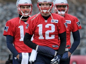 Patriots quarterbacks Tom Brady (12). Jimmy Garoppolo (left) and Jacoby Brissett (right) warm up for the team's practice in Foxboro, Mass., on Friday, Jan. 20, 2017. The Patriots take on the Steelers in the AFC championship game Sunday night. (Mark Stockwell/The Sun Chronicle via AP)