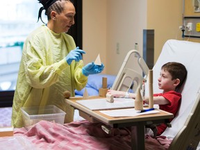 Teacher Anna Kopec works with student Gavin Penill ,7, in the Stollery Childrebs Hospital on Friday January 20, 2017 in Edmonton.  The Stollery School allows patients to continue with their regular school work while in the hospital, to provide normalcy and routine to their days and to help students stay connected to their home schools. For those patients who cannot attend the Stollery classroom in the hospital, a newly funded position by Alberta Education will allow for teaching at the bedside around a child’s needs and medical schedule.