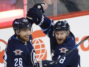 Winnipeg Jets' Bryan Little (18) and Blake Wheeler (26) celebrate Little's goal during first period NHL action in Winnipeg on Saturday, January 21, 2017. (THE CANADIAN PRESS/John Woods)