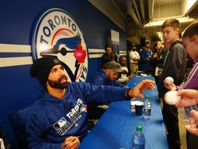 Jose Bautista signs autographs for Blue Jays fans at the Rogers Centre on Saturday. (Michael Peake/Toronto Sun)