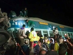 This video frame grab taken and provided by NNIS TV on January 22, 2017 shows people and rescuers looking for victims from a derailed train in southeast India. (AFP PHOTO/NNIS TV)