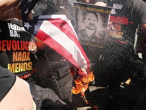 A group tries to burn an American flag as police move in near the site of the Republican National Convention in downtown Cleveland. (Spencer Platt/Getty Images)