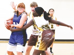 Paige Liebreich, a County Central High School junior high basketball player, shields the ball from three Brooks players Jan. 13 during a junior high tournament held in Vulcan.