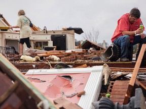 Jeff Bullard sits in what used to be the foyer of his home as his daughter, Jenny Bullard, looks through debris at their home that was damaged by a tornado, Sunday, Jan. 22, 2017, in Adel, Ga. (AP Photo/Branden Camp)