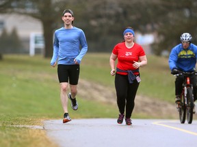 Marc Deshaies wears shorts in the mild weather as he runs with London Life co-worker Christine Paterson through Greenway Park Sunday. The two are training for the Forest City Road Races. (MIKE HENSEN, The London Free Press)