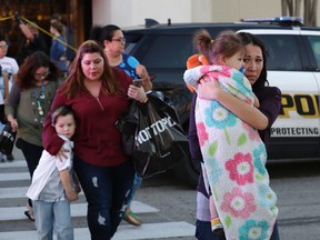 San Antonio police help shoppers exit the Rolling Oaks Mall, Sunday, Jan. 22, 2017, in San Antonio, after a deadly shooting. Authorities say several were injured after a robbery at the shopping mall. (AP Photo/Eric Gay)