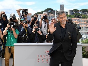 George Clooney waves on May 12, 2016 during a photocall for the film 'Money Monster' at the 69th Cannes Film Festival in Cannes, southern France. / AFP / ANNE-CHRISTINE POUJOULAT (Photo credit should read ANNE-CHRISTINE POUJOULAT/AFP/Getty Images)
