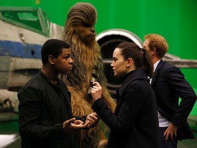 British actors John Boyega (L) and Daisy Ridley (R) speak while Britain's Prince Harry talks with Chewbacca during tour of the Star Wars sets at Pinewood studios in Iver Heath, west of London on April 19, 2016. Photo credit should read ADRIAN DENNIS/AFP/Getty Images)