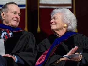 Former President George H.W. Bush and Barbara Bush listen as their son, President George W. Bush, delivers the commencement address during the Texas A&M University graduation ceremony at Reed Arena in College Station, Texas, on December 12, 2008. (SAUL LOEB/Getty Images)