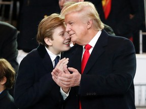 President Donald Trump, right, smiles with his son Barron as they view the 58th Presidential Inauguration parade for President Donald Trump in Washington. Friday, Jan. 20, 2017 (AP Photo/Pablo Martinez Monsivais)