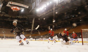 Calgary Flames goalie Brian Elliott dives for the puck at the  pre-game skate before their game with the Toronto Maple Leafs in Toronto on Monday January 23, 2017. Jack Boland/Toronto Sun/Postmedia Network