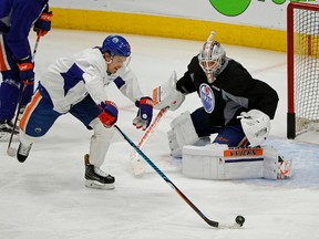 Edmonton Oiler Anton Lander attempts to score on goalie Laurent Brossoit during practice in Edmonton on Jan. 23, 2017. (Larry Wong)