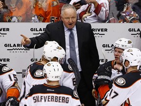 Anaheim Ducks head coach Randy Carlyle, top, gives instructions to his players, including right wing Ondrej Kase (86), center Ryan Kesler (17), defenseman Hampus Lindholm (47) and right wing Jakob Silfverberg (33) during the third period of an NHL hockey game against the Arizona Coyotes Saturday, Jan. 14, 2017, in Glendale, Ariz. The Ducks defeated the Coyotes 3-0. (AP Photo/Ross D. Franklin)