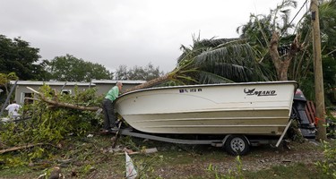 Jose Luis Diaz checks damages to his boat after severe weather passed through the area in the early morning hours, Monday, Jan. 23, 2017, in Miami Springs, Fla. (AP Photo/Alan Diaz)