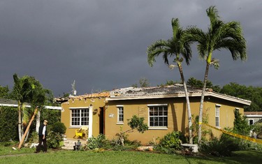 A man walks into a home with roof damages caused by severe weather in the early morning hours, Monday, Jan. 23, 2017, in Miami Springs, Fla. (AP Photo/Alan Diaz)