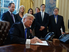 U.S. President Donald Trump signs an executive order on the Keystone XL pipeline in the Oval Office of the White House in Washington on Tuesday, Jan. 24, 2017. (AP Photo/Evan Vucci)