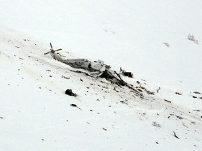 The wreckage of a helicopter lies in the snow after crashing in the Campo Felice ski area, central Italy, Tuesday, Jan. 24, 2017. (AP Photo/Gregorio Borgia)