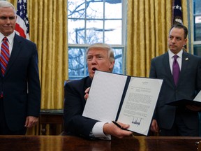 In this Monday, Jan. 23, 2017 file photo, President Donald Trump shows off an executive order to withdraw the U.S. from the 12-nation Trans-Pacific Partnership trade pact in the Oval Office of the White House in Washington. (AP Photo/Evan Vucci, File)