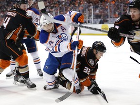 Edmonton Oilers' Jordan Eberle, center left, goes after the puck as Anaheim Ducks' Jakob Silfverberg, of Sweden, falls to the ice during the first period of an NHL hockey game Friday, Feb. 26, 2016, in Anaheim, Calif.