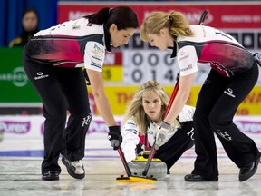 Team Jones skip Jennifer Jones, centre, delivers a stone as lead Dawn McEwen, right, and second Jill Officer sweep during a game last month in Brandon. (MICHAEL BURNS/FOR THE CANADIAN PRESS)