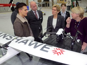 Fanshawe student Nikola Zirkovic, left, gives Ontario Premier Kathleen Wynne at the Fanshawe College Aviation Centre in London, Ontario on Tuesday January 24, 2017. From left, Zirkovic, Steve Patterson, head of Fanshawe's Aviation program, and MPP Deb Matthews (MORRIS LAMONT, The London Free Press)