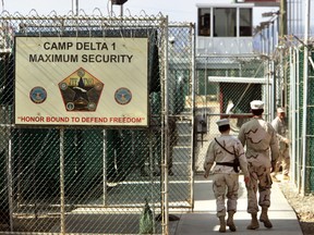 In this June 27, 2006 file photo, reviewed by a US Department of Defense official, US military guards walk within Camp Delta military-run prison, at the Guantanamo Bay US Naval Base, Cuba. A draft executive order shows President Donald Trump asking for a review of America’s methods for interrogation terror suspects and whether the U.S. should reopen CIA-run “black site” prisons outside the U.S. (AP Photo/Brennan Linsley, file)