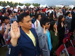 One hundred new Canadians say the oath during a special Canadian citizenship ceremony in Calgary, Alta. on August 19, 2014. (Darren Makowichuk/Postmedia Network)