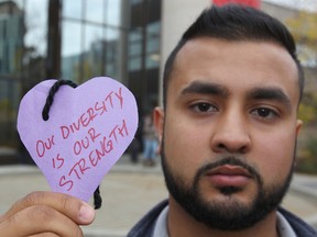 Umair Tazeem, president of the University of Calgary Muslim Students’ Association, holds up his message of support in Calgary on Oct. 4, 2016, following the discovery of dozens of anti-Muslim posters on the main campus. (Jim Wells/Postmedia Network file photo)