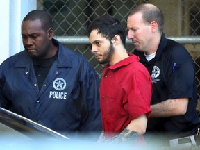 Esteban Santiago (center) was indicted on 22 counts on Thursday for a shooting rampage Jan. 6 at the Fort Lauderdale-Hollywood International Airport baggage claim area that left several people dead and others wounded. (Amy Beth Bennett/South Florida Sun-Sentinel via AP)