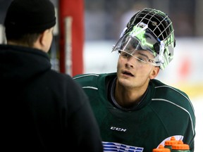 Tyler Parsons of the Knights talks to trainer Doug Stacey on the bench during practice at Budweiser Gardens. (MIKE HENSEN, The London Free Press)