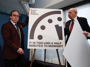 From left, Lawrence Krauss, theoretical physicist; Thomas Pickering, co-chair of the International Crisis Group; and David Titley, a nationally known expert in the field of climate, the Arctic, and national security, unveil the Doomsday Clock during a news conference at the National Press Club in Washington, Thursday, Jan. 26, 2017. (AP Photo/Carolyn Kaster)