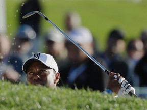 Tiger Woods hits out of a bunker on the 17th hole of the south course during the first round of the Farmers Insurance Open on Jan. 26, 2017, at Torrey Pines Golf Course. (AP Photo/Gregory Bull)
